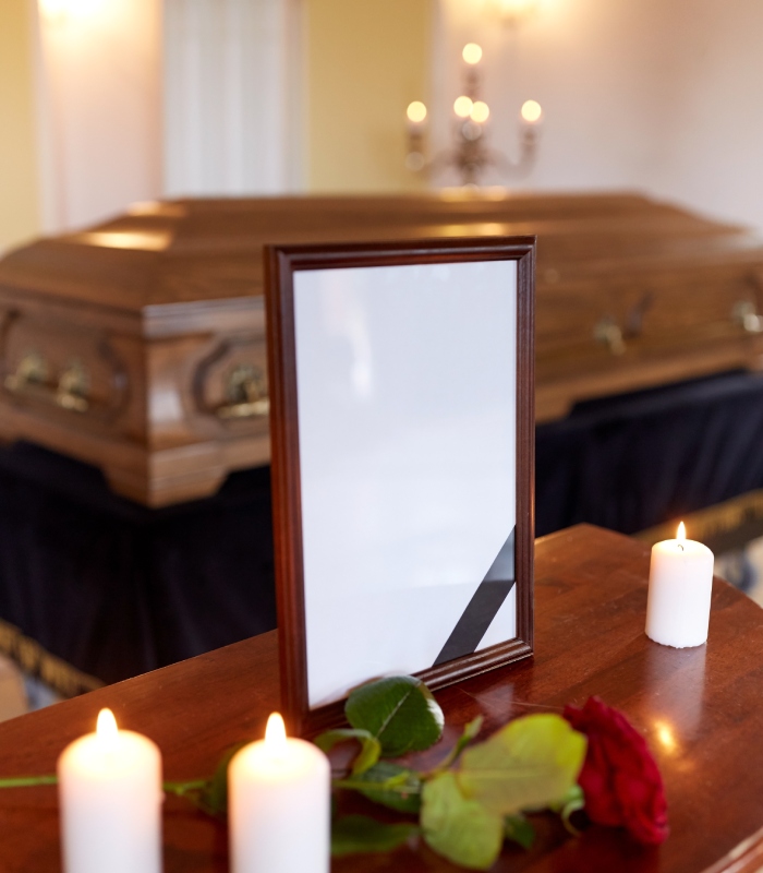 Chambre funéraire avec cercueil, bougies, rose rouge et cadre de recueillement