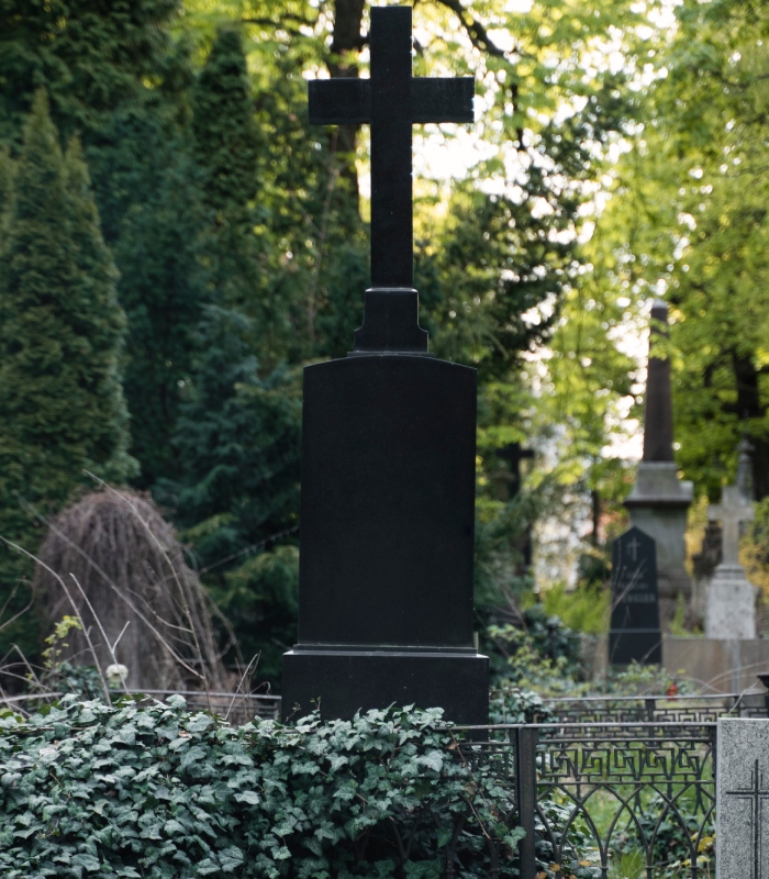 Monument funéraire avec croix dans un cimetière arboré