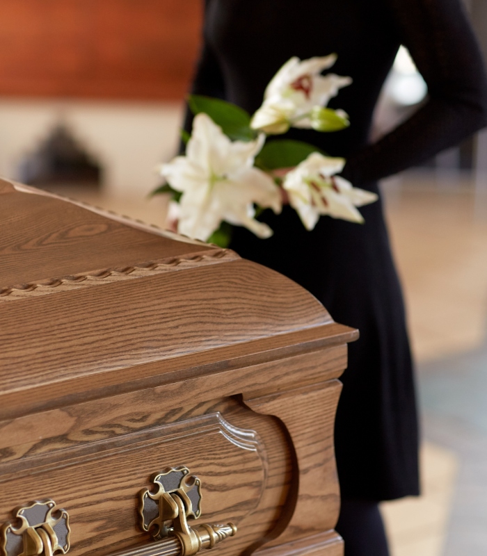 Cercueil en bois avec fleurs blanches lors d’une cérémonie funéraire